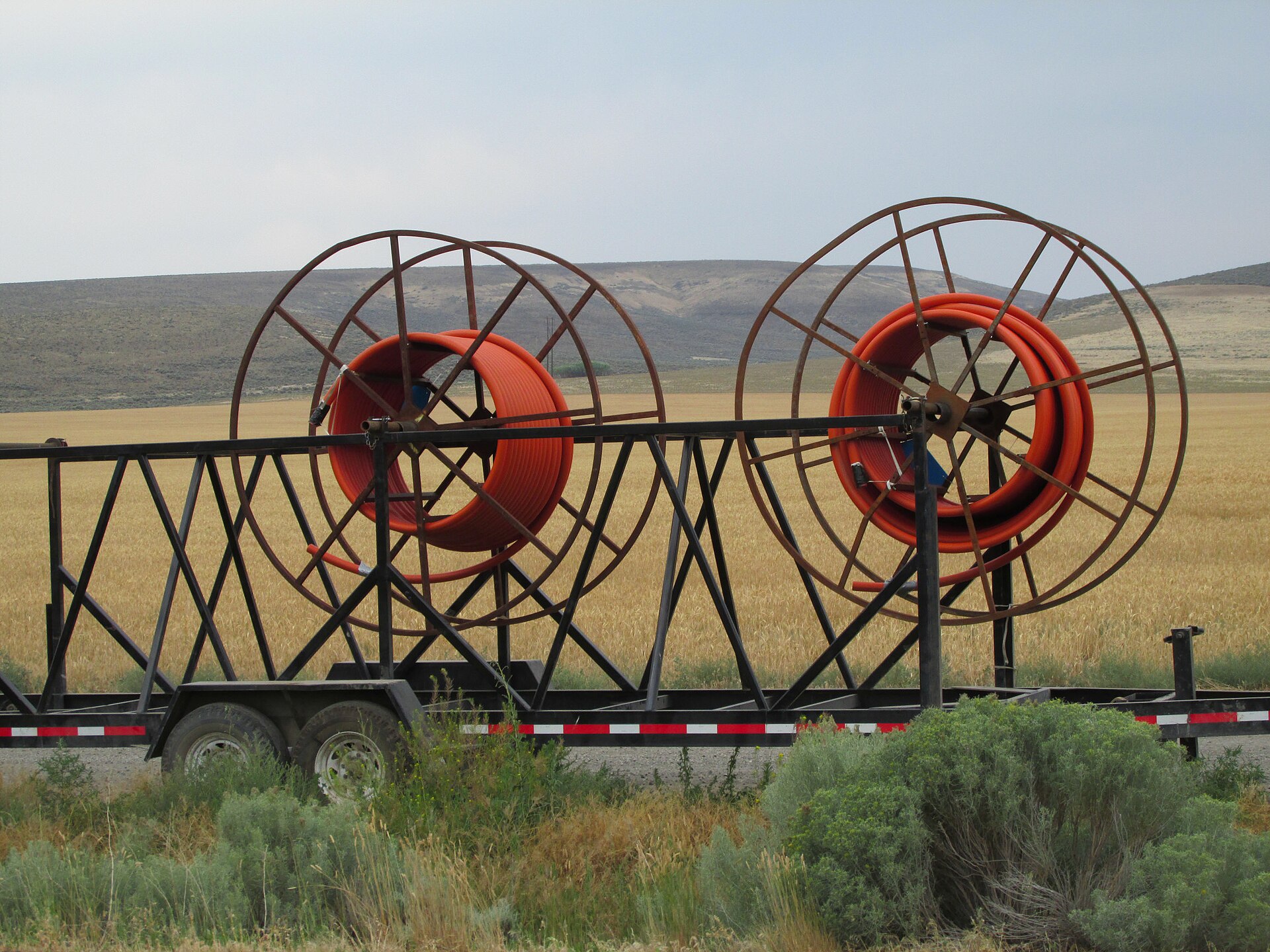 A reel of fibre optic cable being laid along a roadside