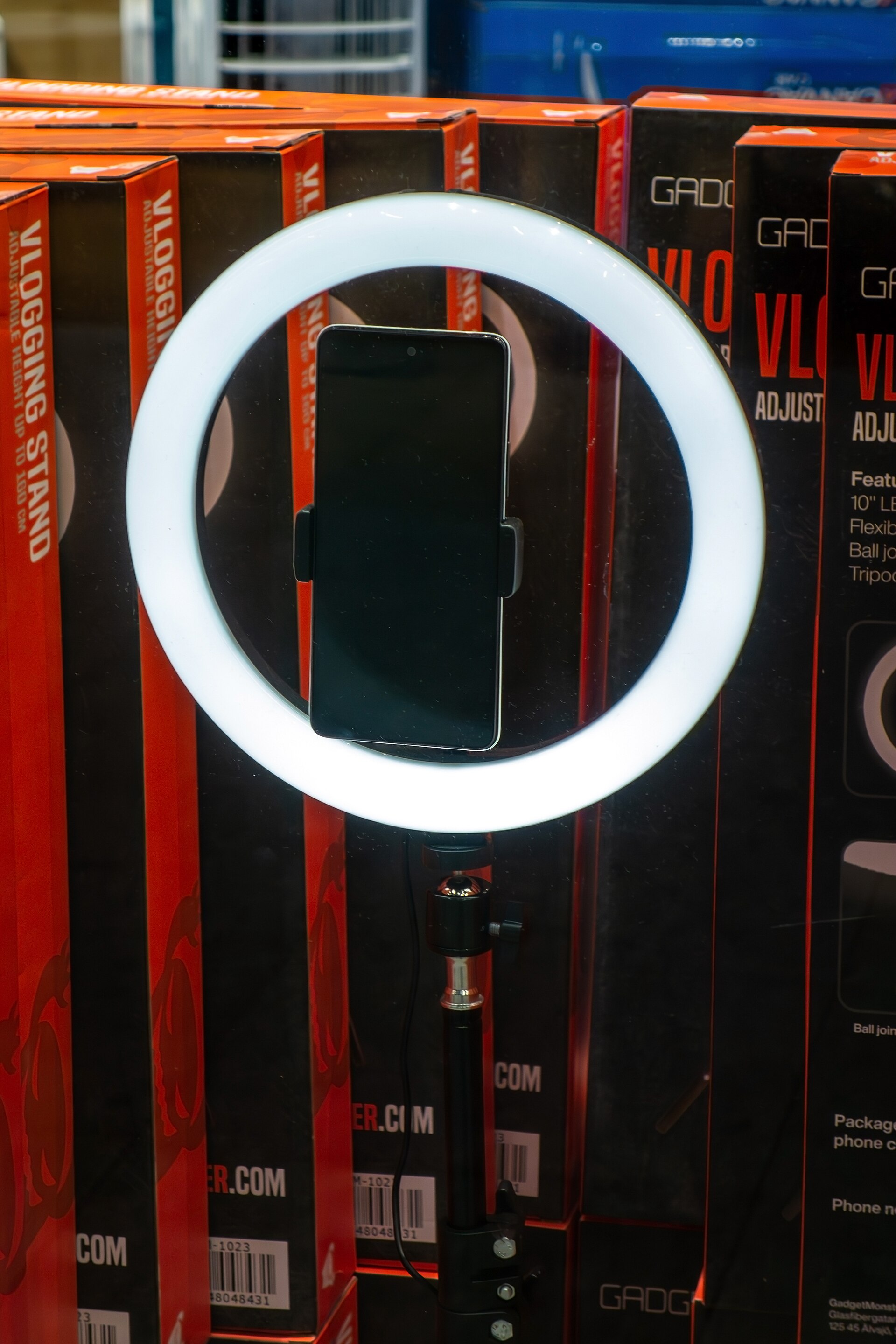 A ring light and a smartphone mounted on a tripod, set up for recording video